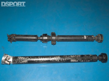 Carbon fiber driveshaft next to the original driveshaft.