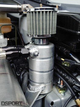 A custom aluminum oil catch tank connected with –AN fittings relieves crankcase pressure and traps oil carried in blow-by gasses