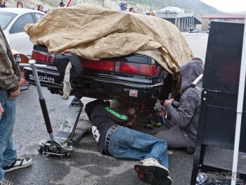 guys working on car in the rain at  bandimere speedway